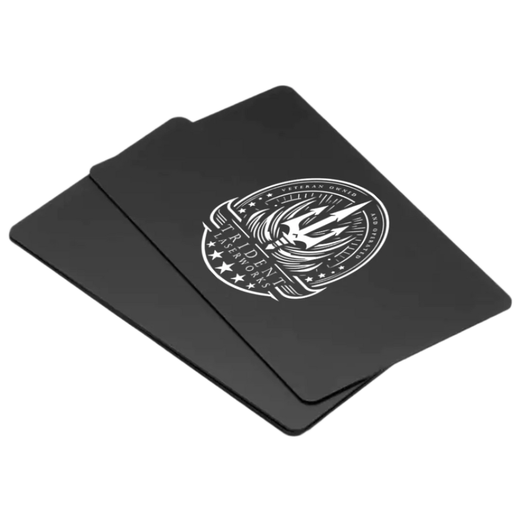A stack of black aluminum business cards with a single-sided laser engraved design featuring an emblem or logo.