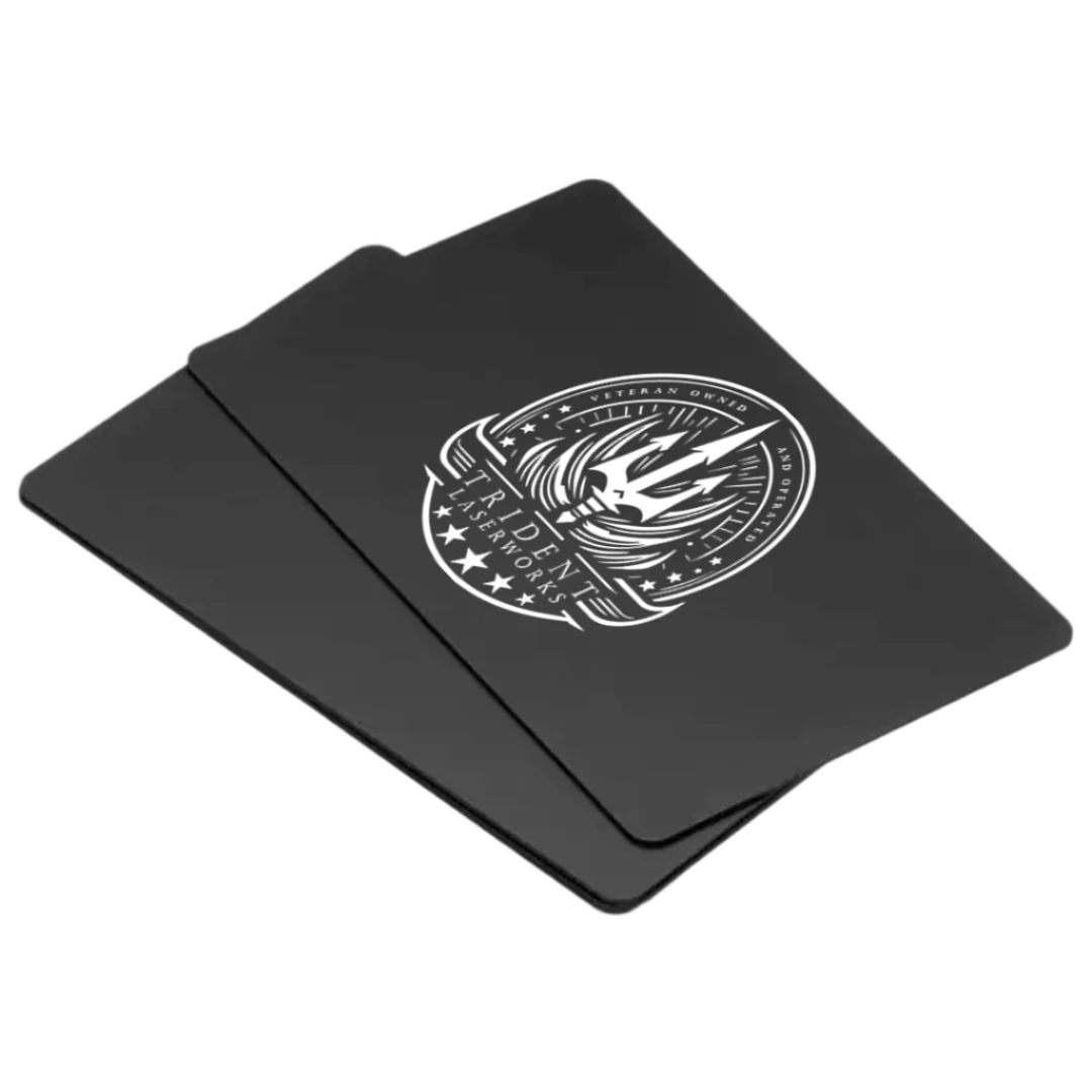 A stack of black aluminum business cards with a single-sided laser engraved design featuring an emblem or logo.