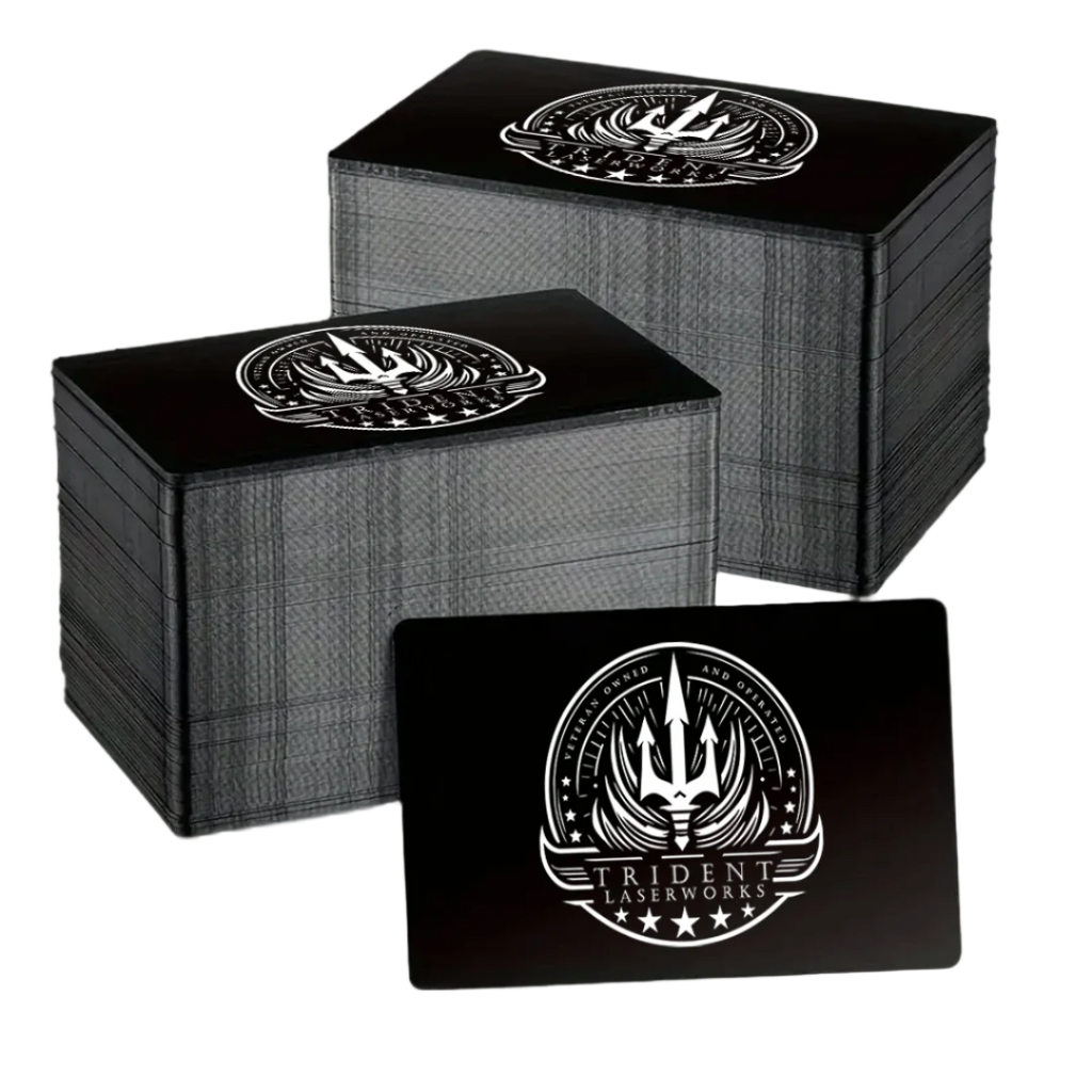 A stack of black aluminum business cards with a single-sided laser engraved design featuring an emblem or logo.