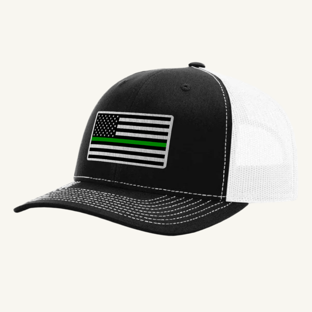 A black and white trucker hat with an acrylic patch on the front displaying the Thin Green Line American Flag.