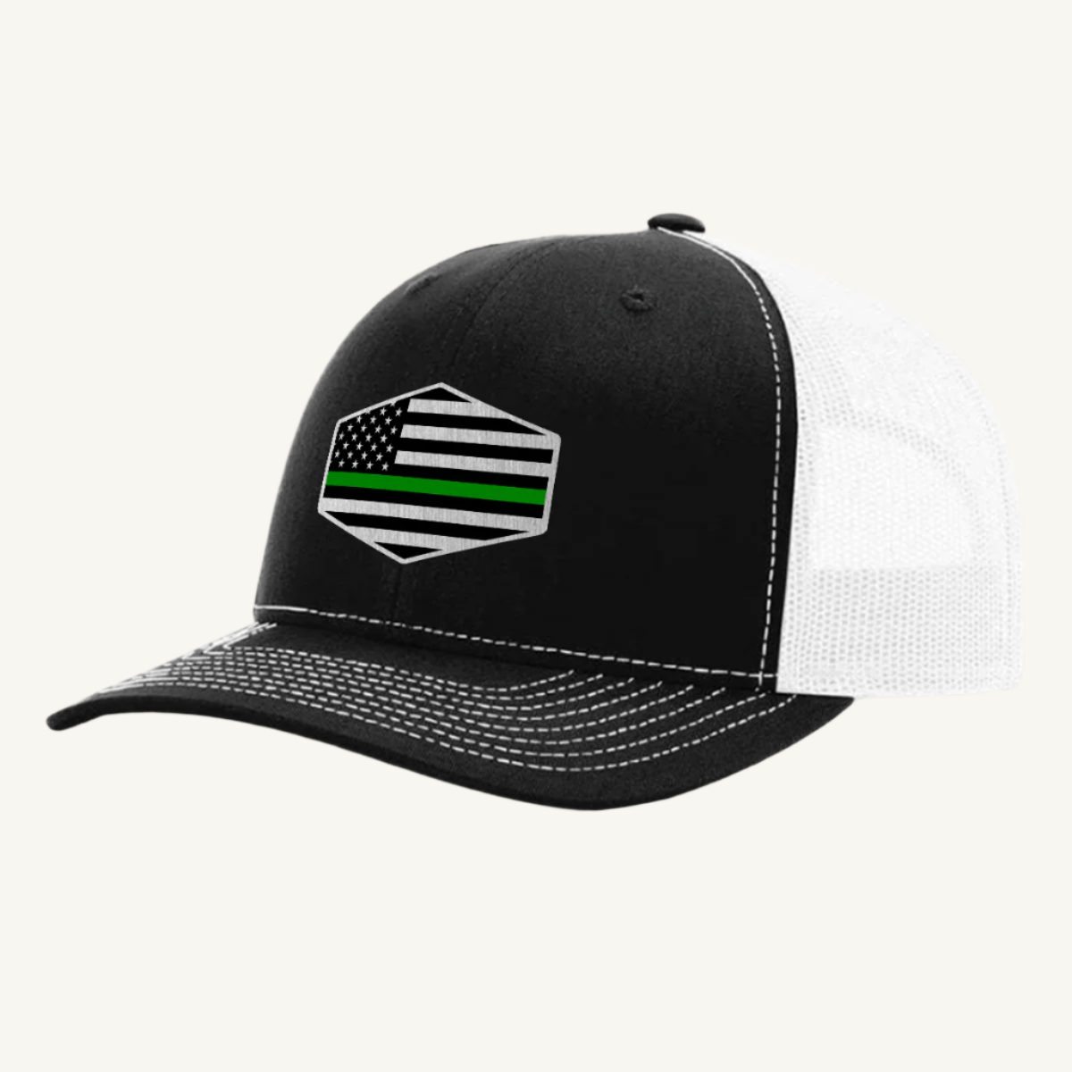 A black and white trucker hat with an acrylic patch on the front displaying the Thin Green Line American Flag.