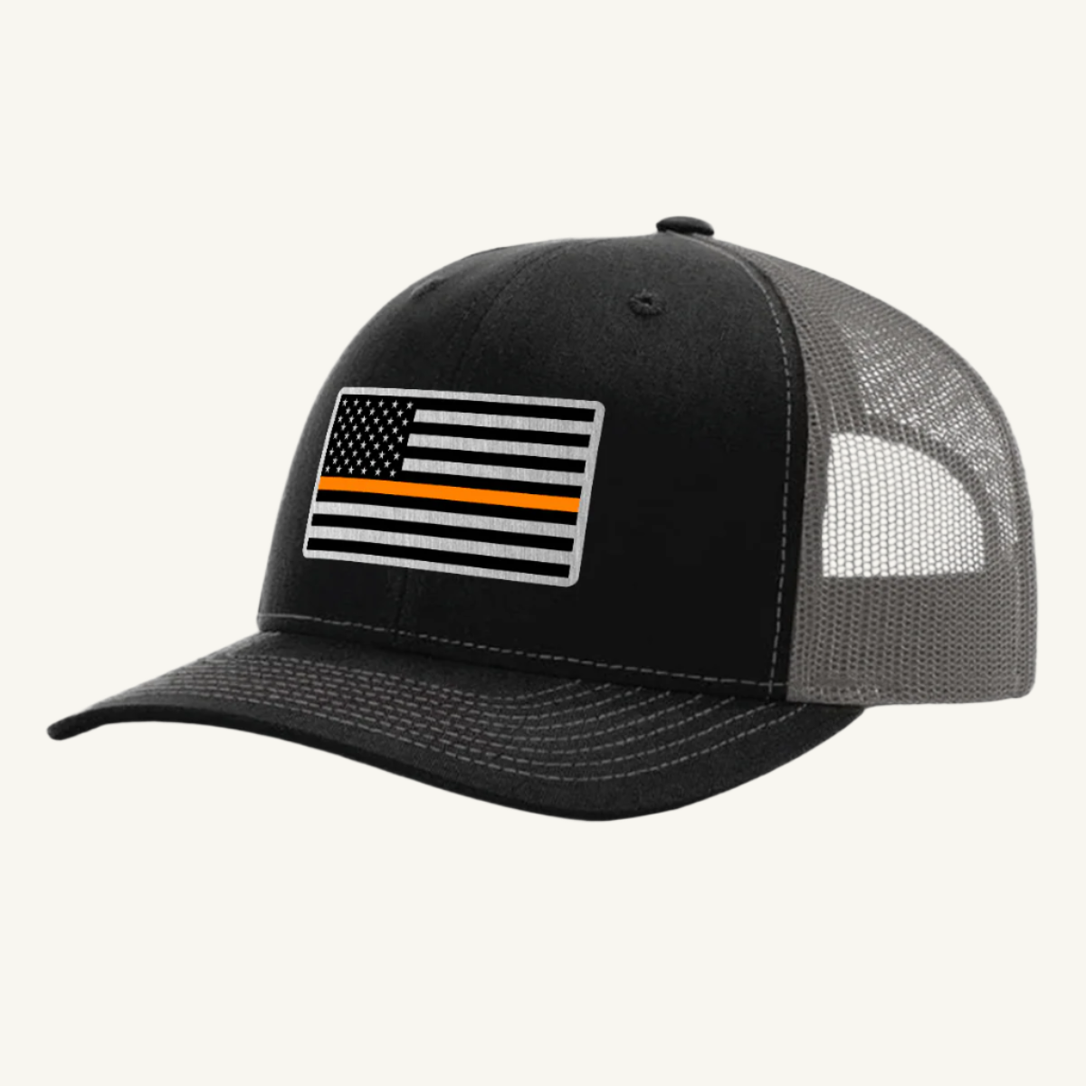 A black and gray trucker hat with an acrylic patch on the front featuring the Thin Orange Line American Flag.