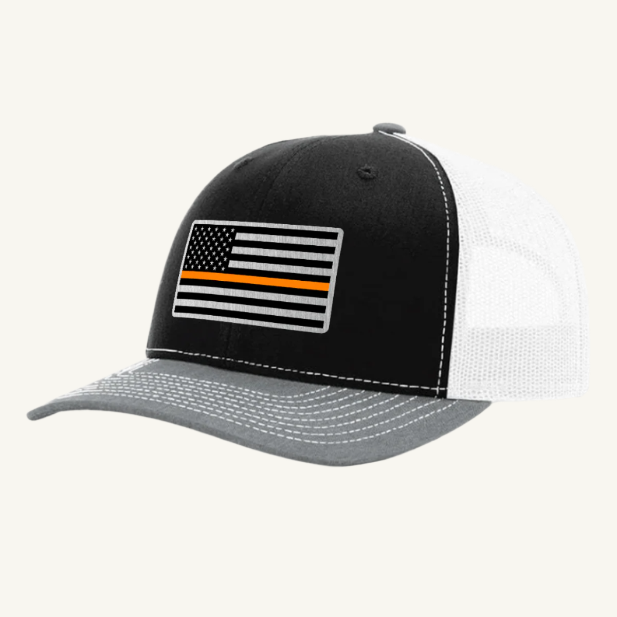 A black, gray, and white trucker hat with an acrylic patch on the front featuring the Thin Orange Line American Flag.