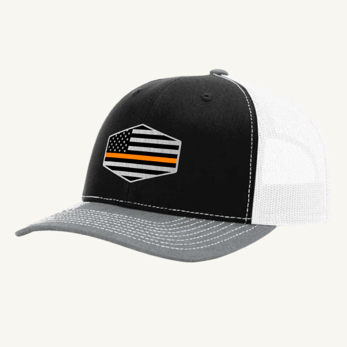 A black, gray, and white trucker hat with an acrylic patch on the front featuring the Thin Orange Line American Flag.