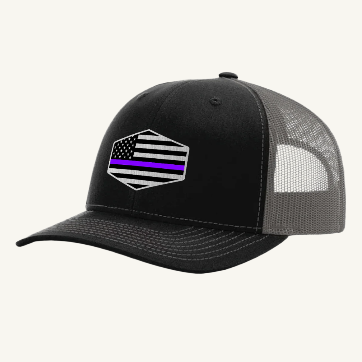 A black and gray trucker hat with an acrylic patch on the front featuring the Thin Purple Line American Flag.