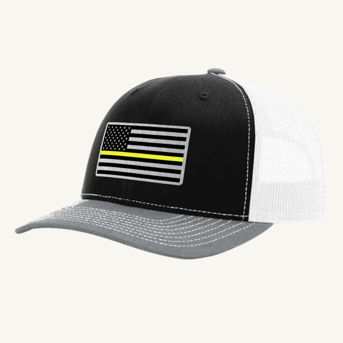 A black, heather gray, and white trucker hat with a thin yellow line American flag acrylic patch on the front.
