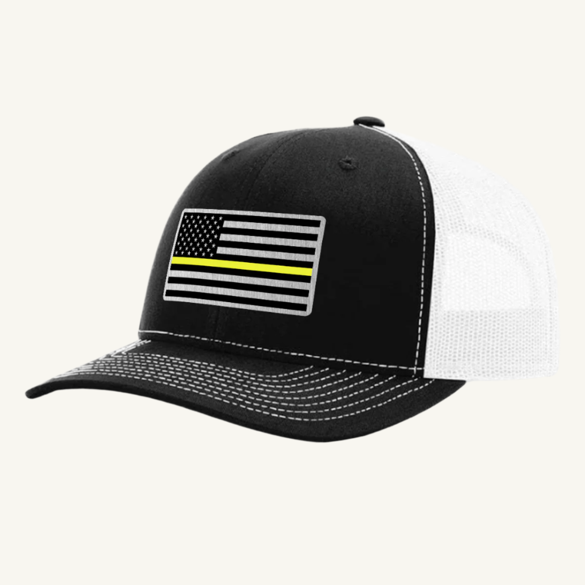 A black and white trucker hat with a thin yellow line American flag acrylic patch on the front.