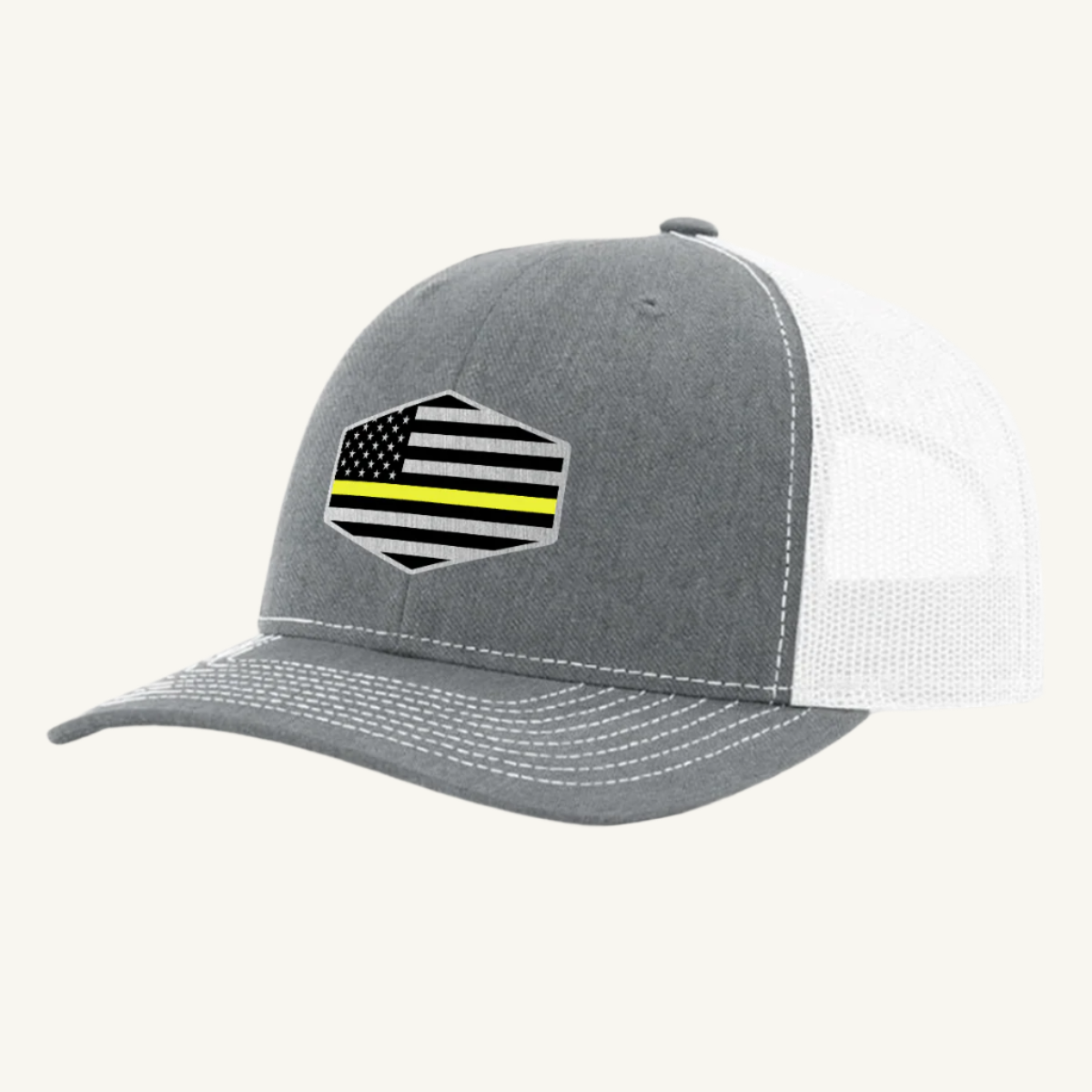 A heather gray & white trucker hat with a thin yellow line American flag acrylic patch on the front.